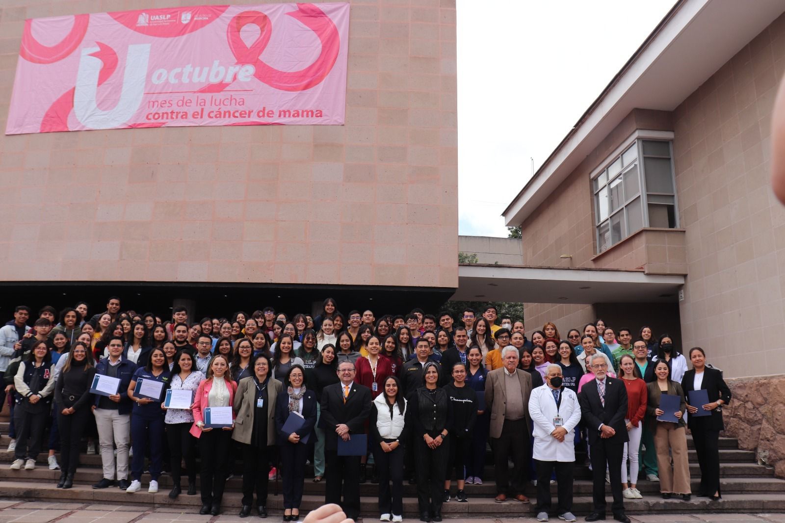 Fotografía de estudiantes de la carrera de fisioterapia a las afueras del auditorio de la facultad de medicina