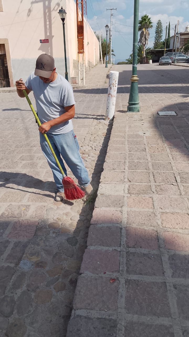 Fotogafía de un trabajador barriendo la plaza principal de Bocas