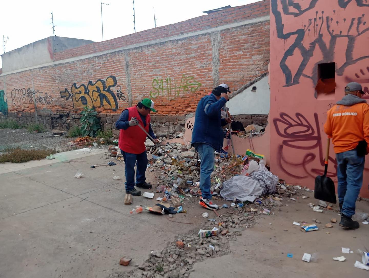 Fotografía de trabajadores municipales retirando montones de basura de la vía pública