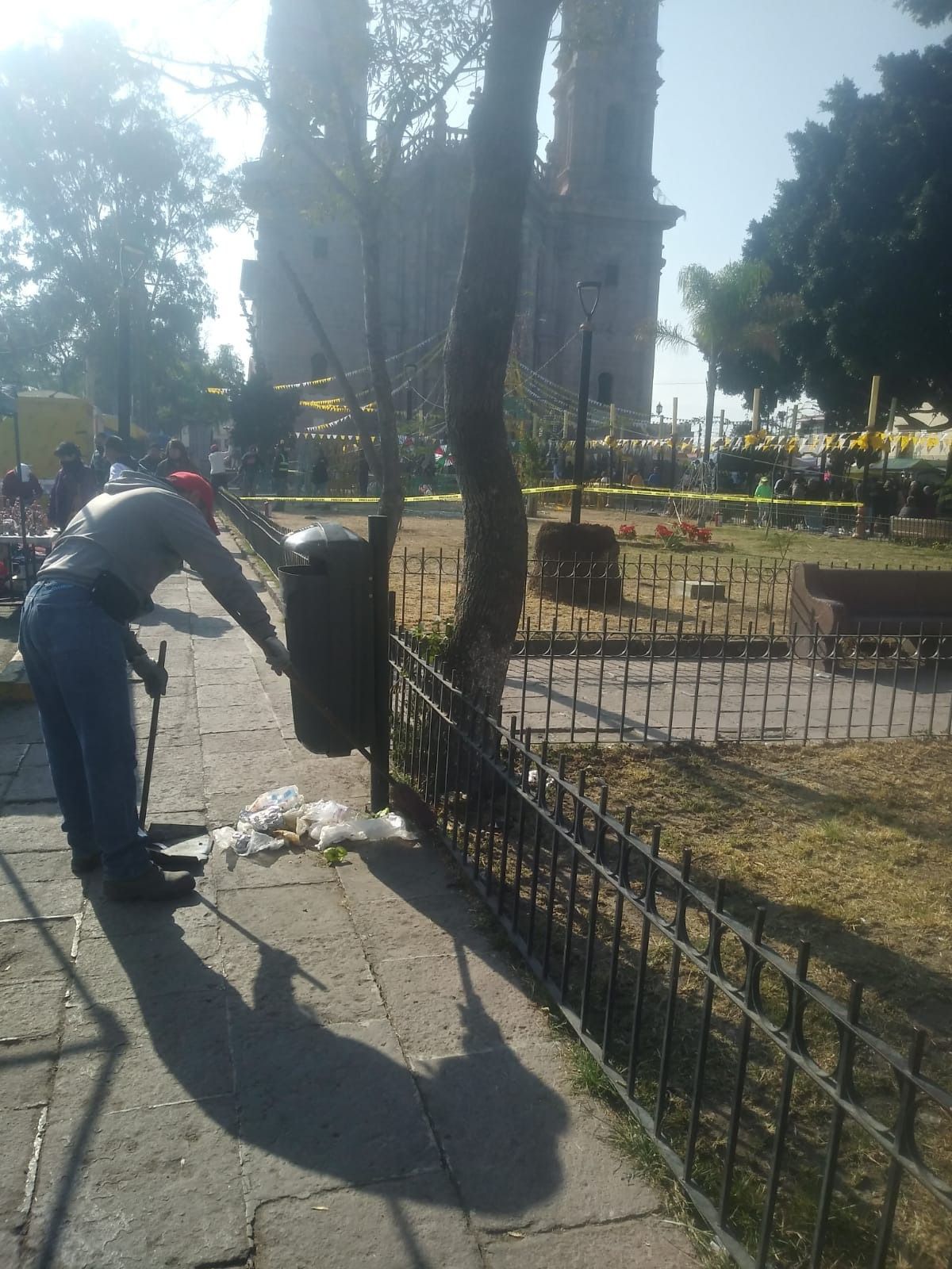 Fotografía de un hombre colocando un bote de basura