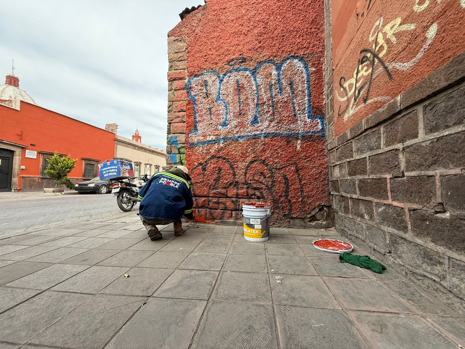 Fotografía de un trabajador removiendo graffiti de una pared