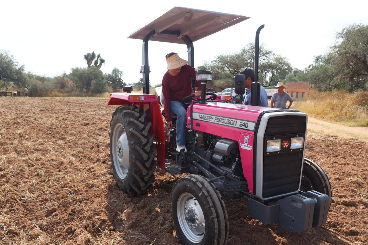 Fotografía de una señora manejando un tractor rosa