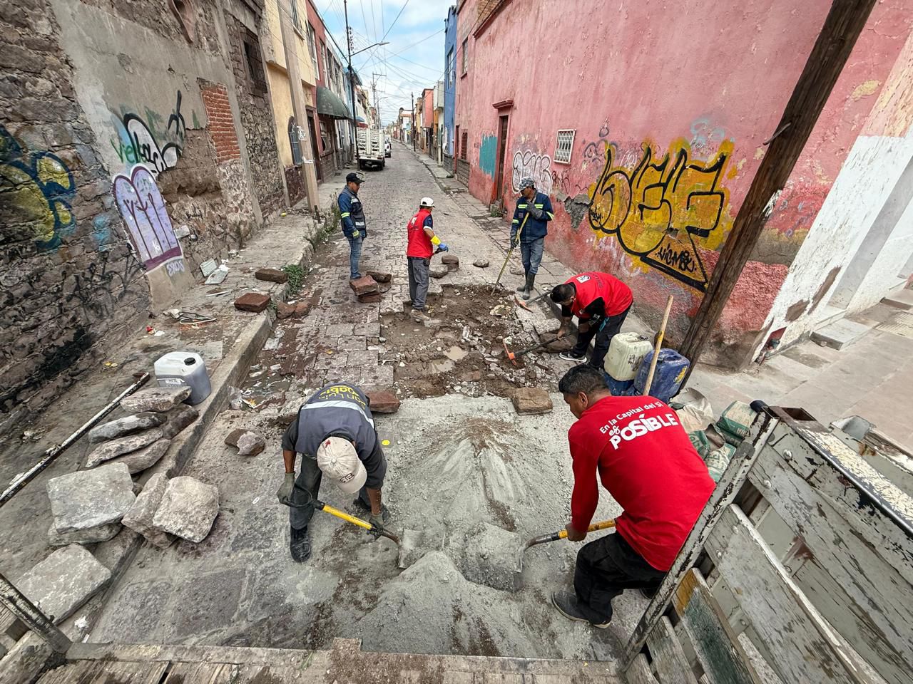 Fotografía de trabajadores municipales colocando adoquines en el suelo